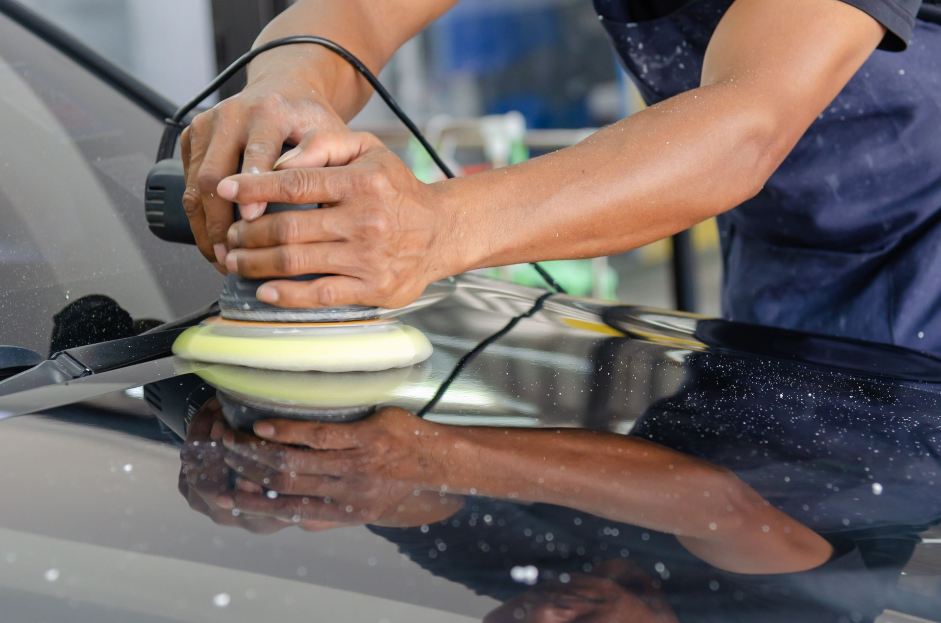 Exterior detailing service - machine polisher working silver body paint