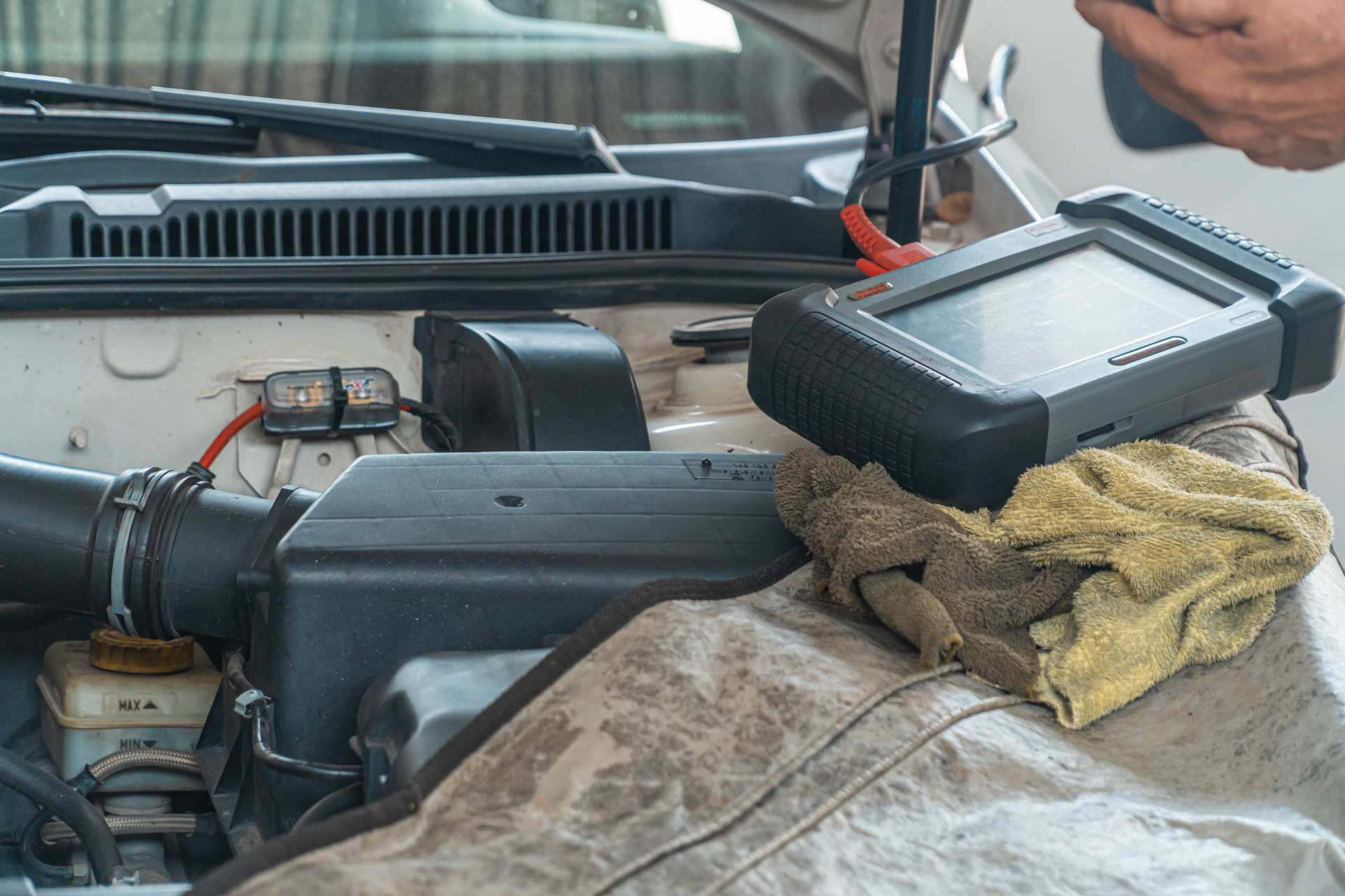 Car diagnostics service - diagnostic scan tool resting on an engine bay
