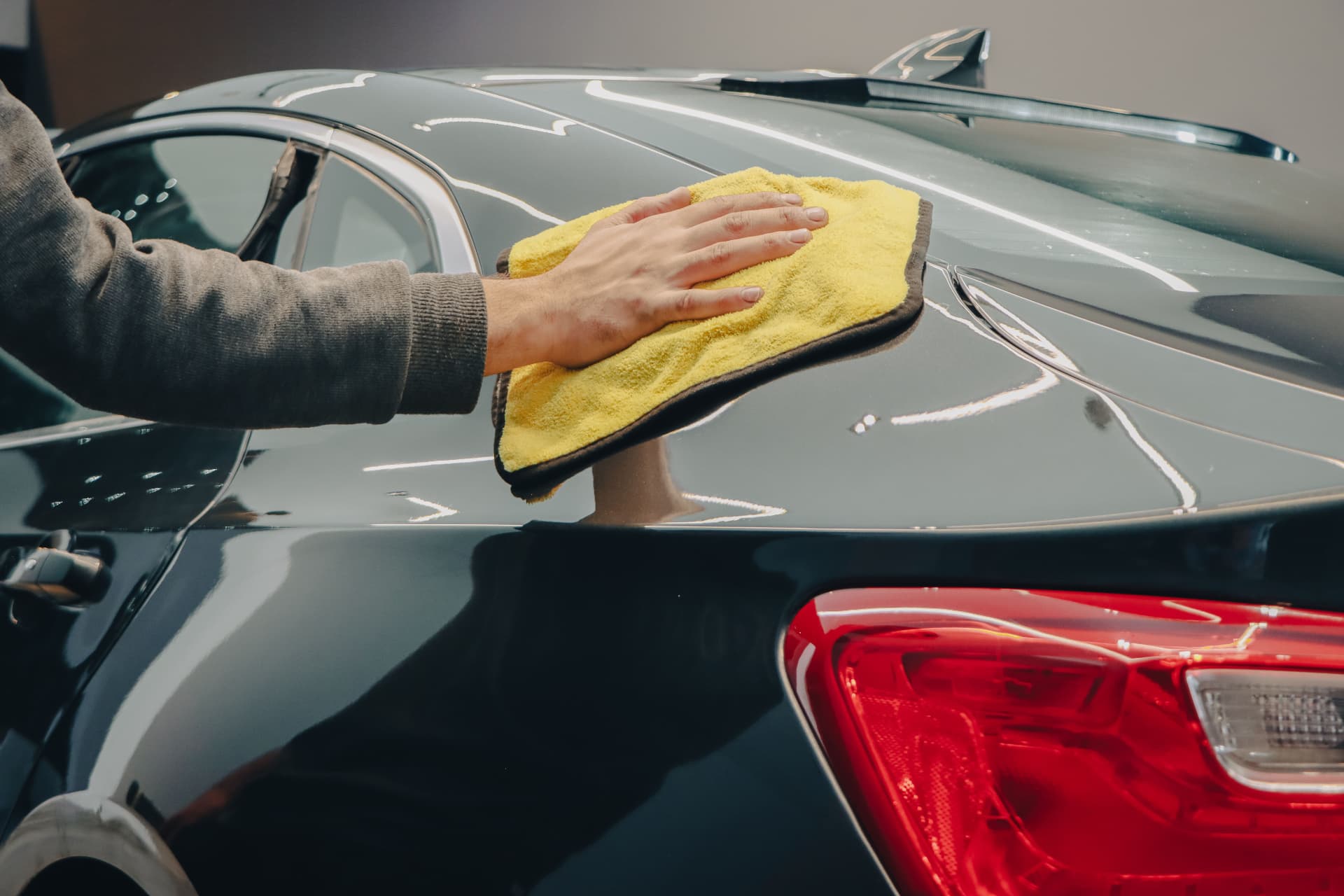 Car polishing service - hand finishing dark paint with a microfiber cloth